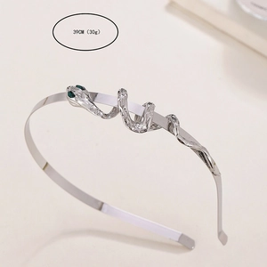 Close-up of silver metal snake headband with green gemstone eyes and 39cm length