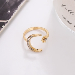 Close-up of gold moon and star ring with micro-pave rhinestones in a lifestyle setting