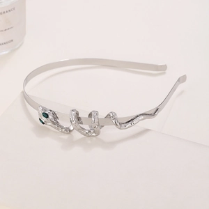 Detailed side view of silver snake headband with green gemstone eyes and textured metal
