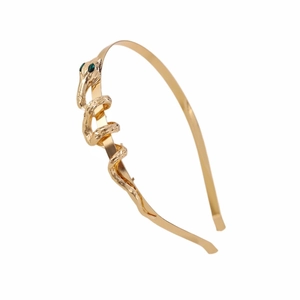 Golden snake-shaped headband with green gemstone eyes on minimalist white background