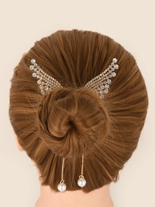 Detail of angel wing hair clip with rhinestones, golden chains and white pearls