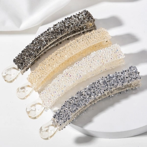 Barrettes banane en cristal étincelant en quatre couleurs sur fond de soie blanche