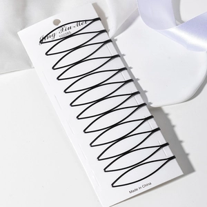 Set mit 10 schwarzen Metall-Haarklammern im Wellendesign ordentlich auf weißer Karte