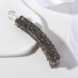 Gros plan détaillé des strass gris sur une barrette banane en résine fumée
