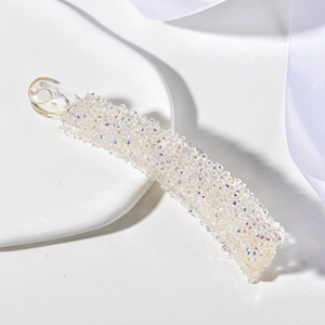 Vue détaillée des strass étincelants et paillettes sur une pince banane en acrylique