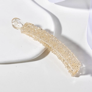 Vue détaillée d'une pince banane dorée champagne ornée de strass brillants scintillants