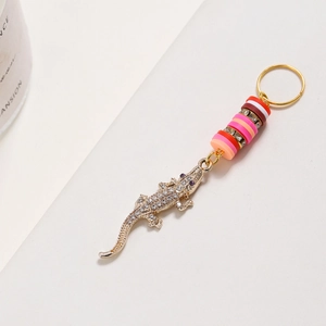 Dettaglio macro della clip per capelli a coccodrillo dorata con strass e perline colorate