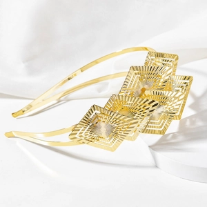 Elegant gold double-layered leaf headband with hollow geometric sunburst texture on white silk