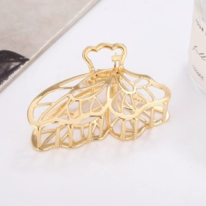 Détail de la pince à cheveux en métal doré ajouré avec motif élégant d'ailes de papillon