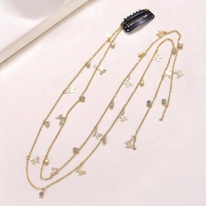 Detail of a gold-tone rhinestone butterfly hair chain with a metal BB clip for styling