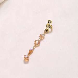 Détail de manchette d'oreille dorée avec frange en cristal champagne et perle florale