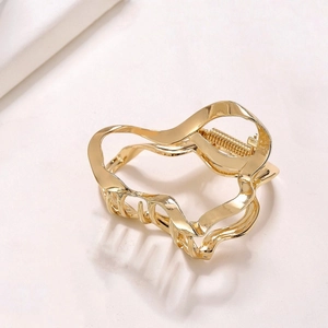 Detailed macro view of the liquid irregular wave metal hair claw clip in gold finish