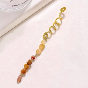Macro view of golden spiral hair coil featuring a gradient of natural stone pendants