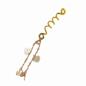 Detail of gold spiral hair rings with celestial moon and star charms in boho style