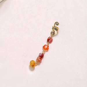 Close-up of golden spiral braid ring featuring multi-colored irregular natural stone pendants