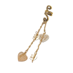 Detail of a golden tassel ear cuff with heart and moon pendants in bohemian style