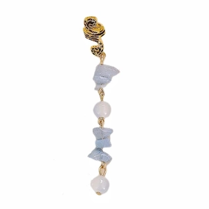 Macro detail of alloy spring pendant featuring light blue stones and purple beads