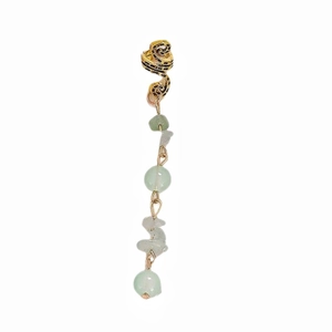 Detailed view of long boho earrings with snakeskin pattern and light green stone beads