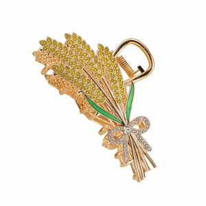 Détail d'une pince à cheveux en épi de blé avec strass jaunes et émail vert élégant