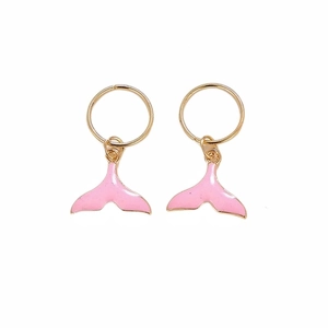 Close-up of golden dreadlock rings with pink mermaid tail charms for hair decoration