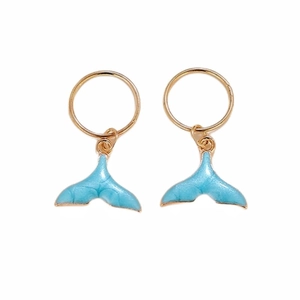 Detail of golden dreadlock cuffs with light blue mermaid tail charms for hair
