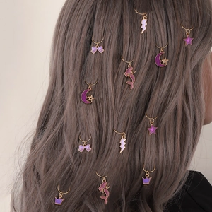 Golden hair rings with purple enamel butterfly and moon charms on braided hair