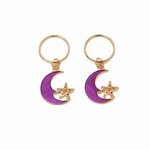 Detail of gold metal hair rings with purple crescent moon and star charms