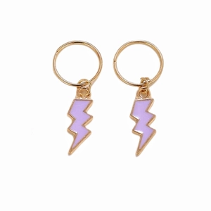 Detail view of golden hair rings featuring purple lightning bolt pendants for braids