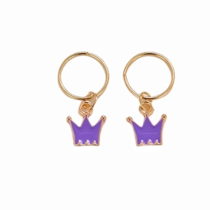 Close-up of golden crown hair ring pendants with vibrant purple enamel finish for braids