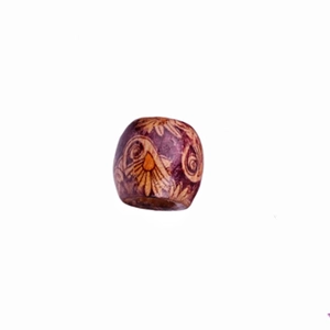 Detailed macro view of a deep purple carved wooden bead with ethnic floral spiral patterns