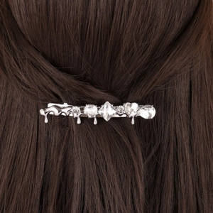 Pince à cheveux argentée design lave avec strass sur de longs cheveux lisses