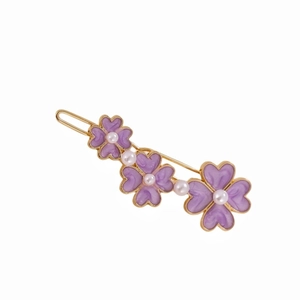 Elegant gold hair clip featuring three purple flowers with white pearls on a white background