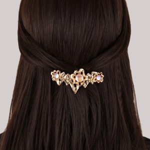 Barrette dorée baroque avec fleurs en pierre de lune portée sur cheveux bruns