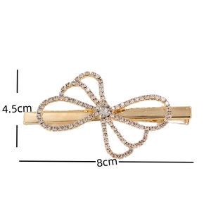 Detail showing the 8cm by 4.5cm dimensions of the rhinestone bow hair clip on a white background