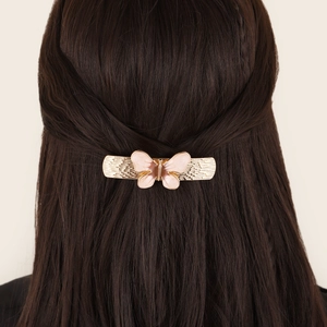 Barrette papillon rose sur cheveux bruns avec base en métal doré élégante