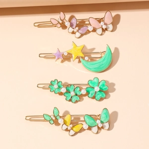 Détail de l'ensemble de quatre barrettes dorées avec motifs papillon et perles