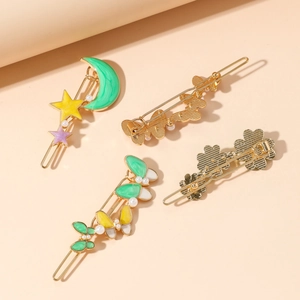 Lot de quatre barrettes à perles dorées avec motifs émaillés papillon, lune et fleur