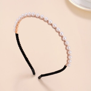 Close-up of rose gold headband with white pearls and sparkling rhinestone flower details