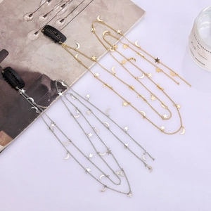 Chaînes de cheveux avec pendentifs étoile et lune dorés et argentés sur fond blanc