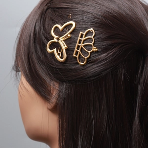 Barrettes à cheveux dorées avec papillon et couronne portées sur cheveux noirs