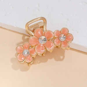 Macro de trois barrettes à fleurs roses avec strass et monture en métal doré