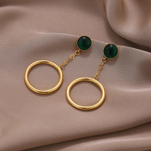 Boucles d'oreilles rétro en or avec pierre vert foncé sur tissu en satin marron