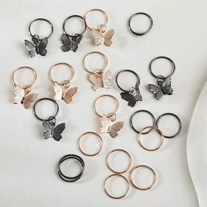 Detail of open hair ring accessories featuring mesh textured butterfly charms in various metal tones