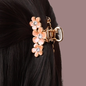 Détail de la pince à cheveux fleurie avec pétales en émail rose et strass brillants