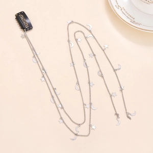 Détail de la chaîne de cheveux étoile et lune argentée avec barrette noire pour coiffure