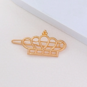 Détail d'une pince à cheveux couronne dorée brillante sur un fond de style minimaliste