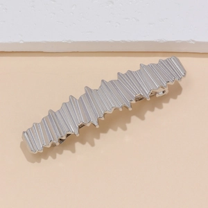 Pince à cheveux minimaliste en métal argenté avec bords ondulés et rayures verticales
