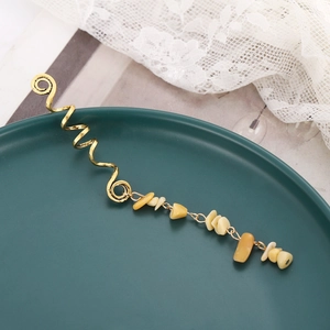 Detail of bohemian gold spiral hair clip featuring irregular natural yellow stone charms