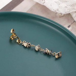 Detail of gold metal spiral clip and long natural spotted stone chain hair accessory