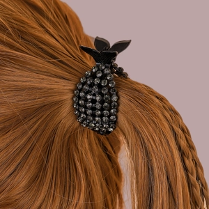 Vista dettagliata di un fermaglio per capelli nero a coda di pesce con strass lucidi